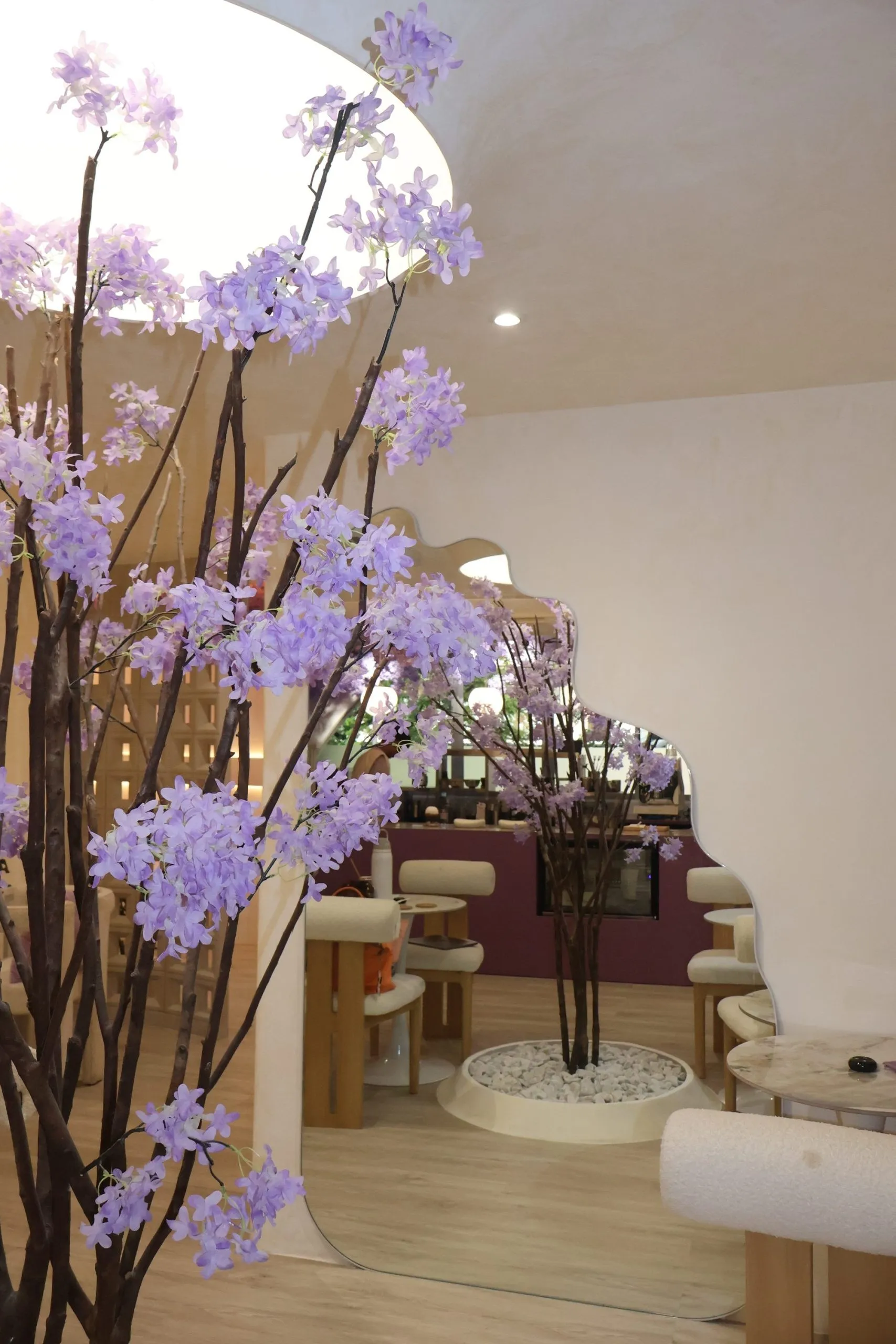Inside Lavande Nails & Café in Legazpi Village: wisteria branches, a curved plaster ceiling and café seating