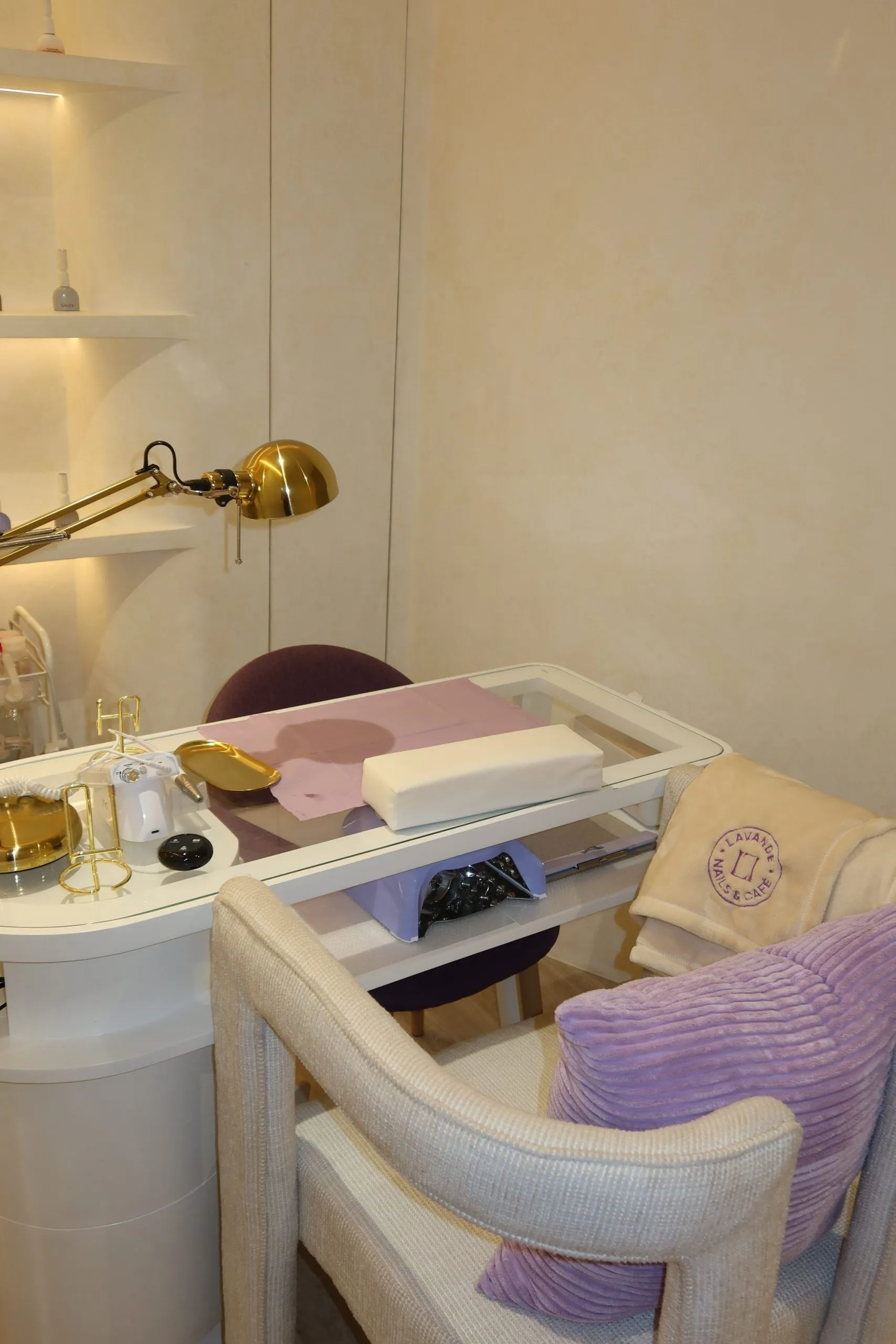 A nail station at Lavande with a brass task lamp and a cream chair