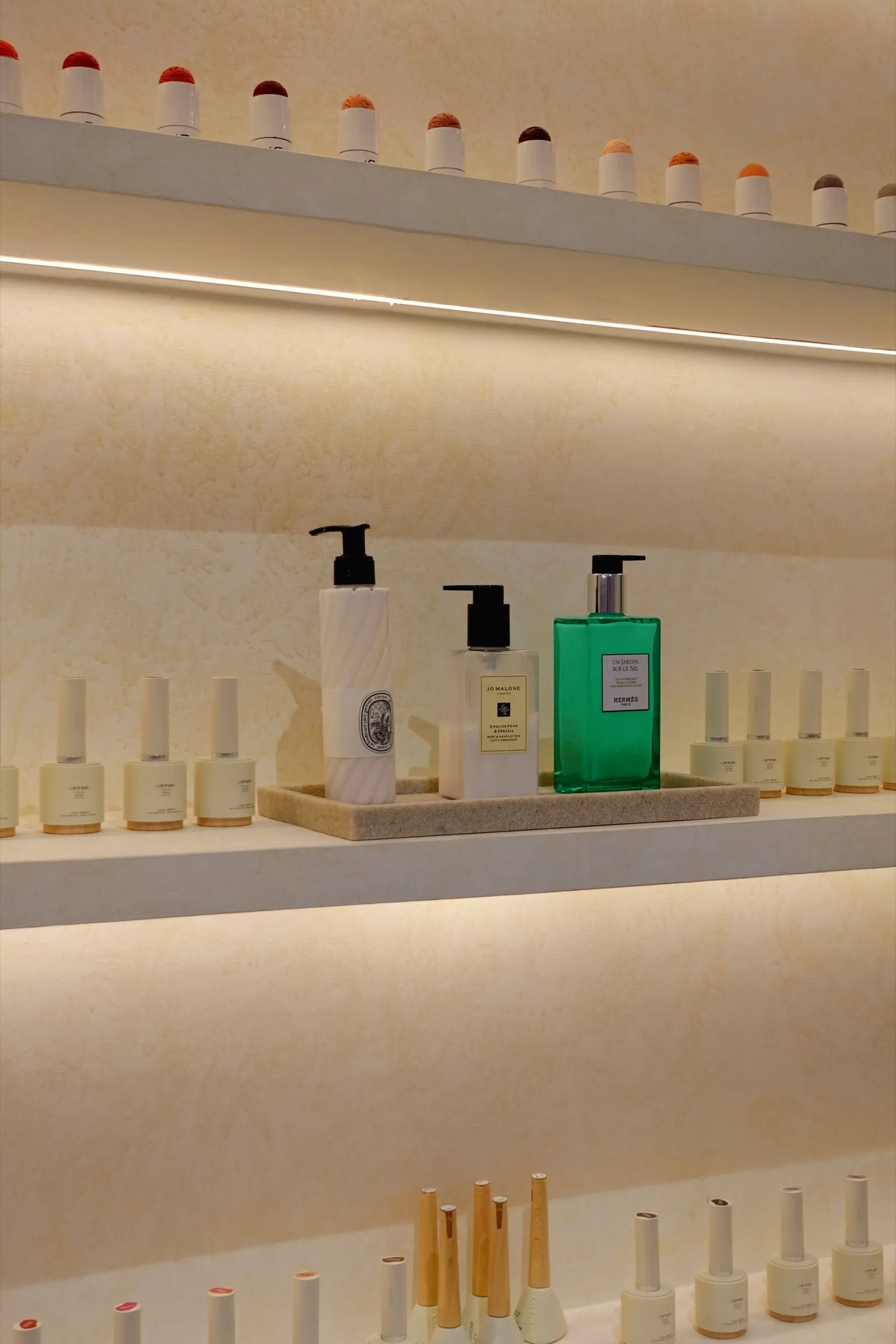 Hand care products and nail polish on softly lit shelves at Lavande